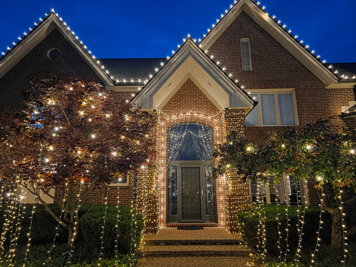 Multi-story building with warm-white string lights along staircases and walkways