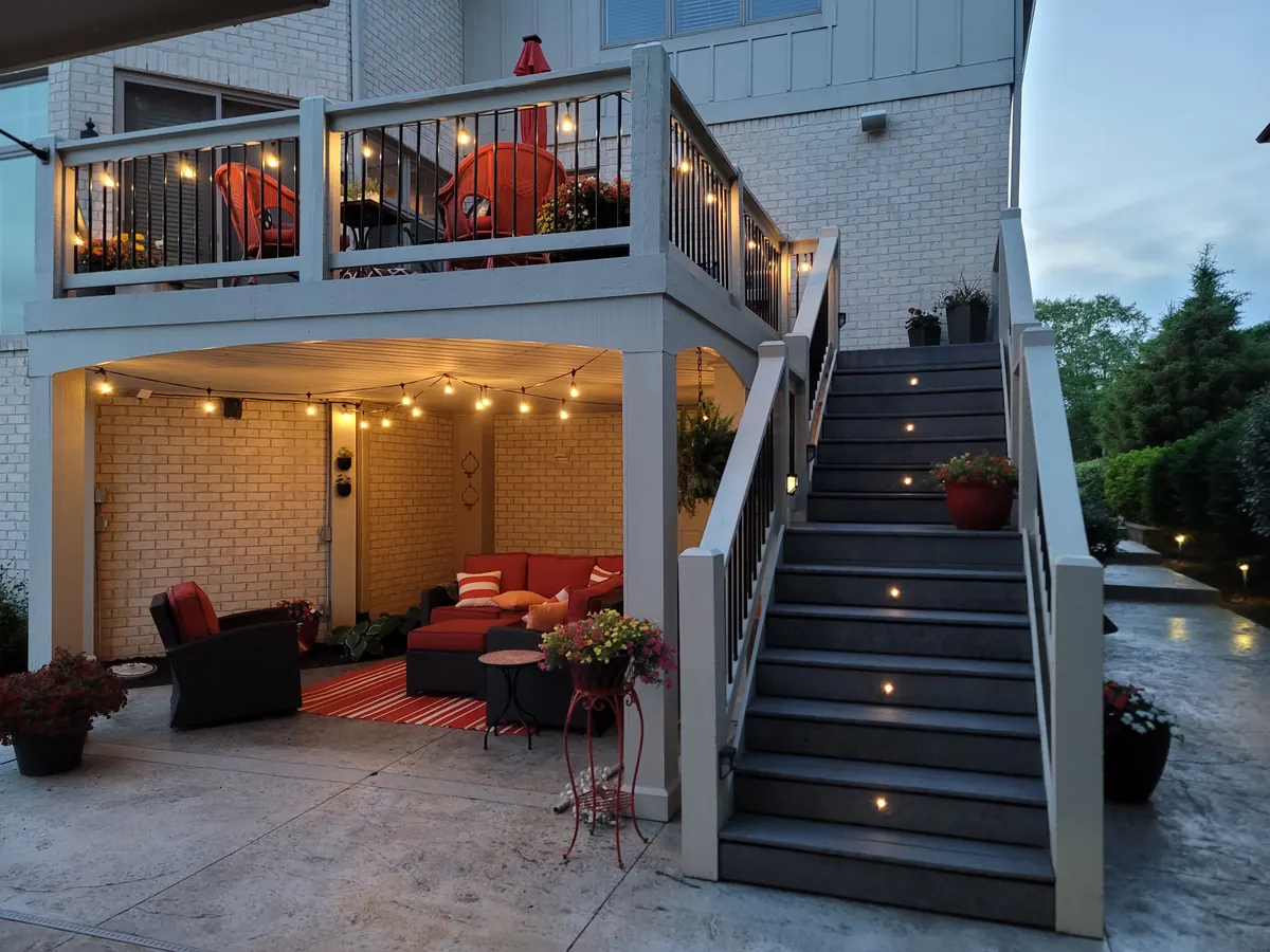 Modern brick and stone home with warm uplighting on facade and landscape