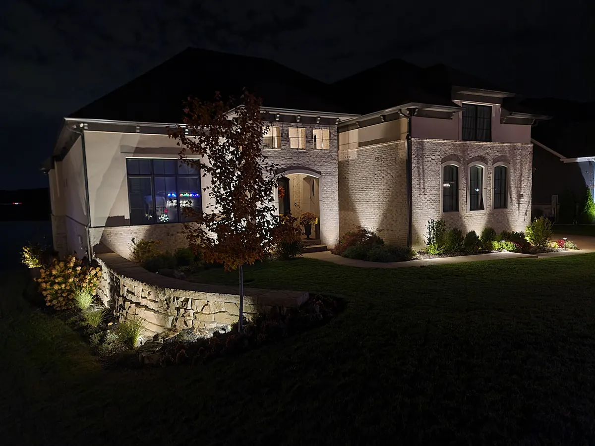 Modern open-concept home with glass walls and dramatic exterior accent lighting