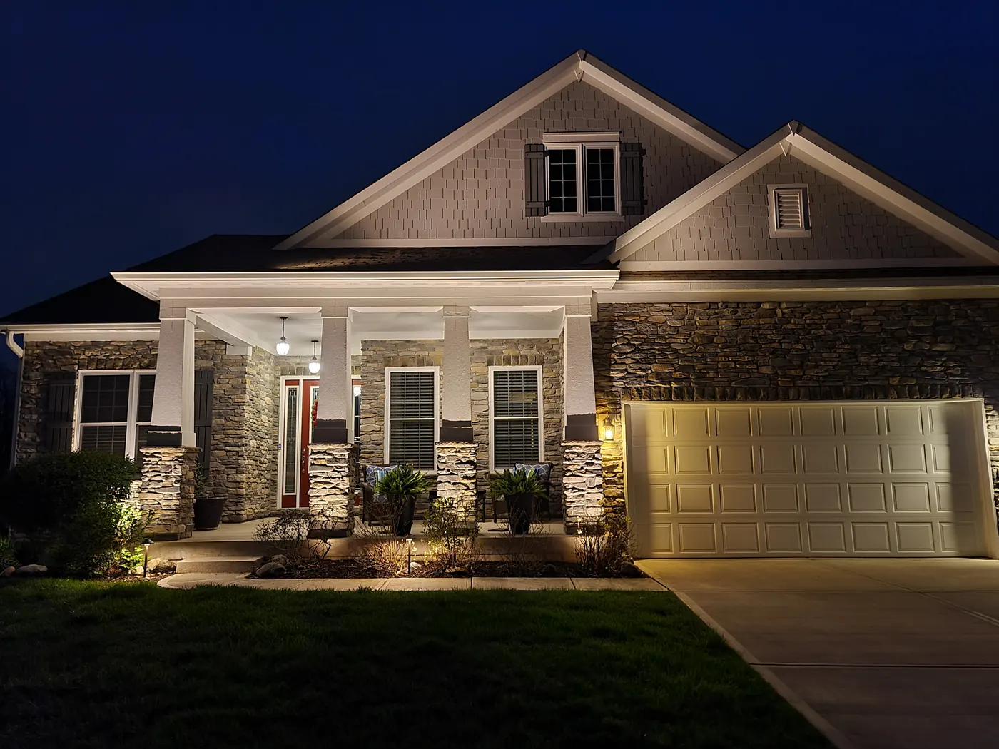 Modern Indianapolis home with warm-white facade uplighting and landscape accents